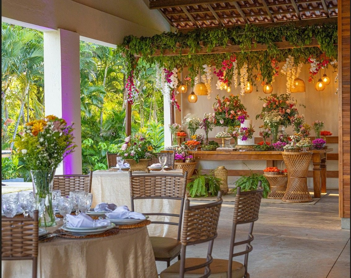 Salão de casamento com decoração floral e jardim ao fundo
