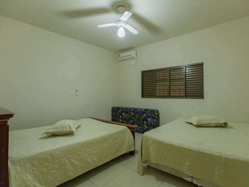 Quarto organizado com duas camas e ar-condicionado
